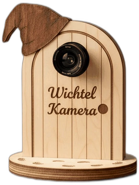 Die Wichtelkamera von vorn, mit Objektiv, eingebrannter Schrift und dem Sockel voller Fußspuren.